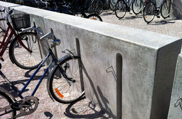 Nowoczesny stojak rowerowy z betonu architektonicznego. W wersji na 3 lub 6 stanowisk rowerowych.