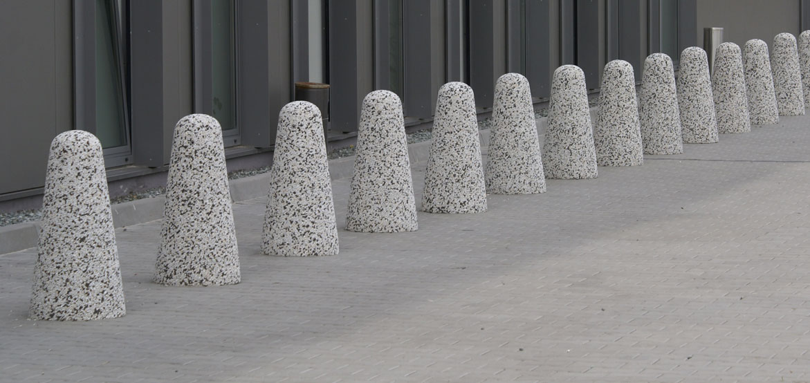 Pal parkingowy wykonany w technologii betonu płukanego, o średnicy 40 cm i wysokości 80 cm.